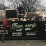Flannery's movers standing by the junk and trash removal dumpster