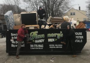 Flannery's movers standing by the junk and trash removal dumpster
