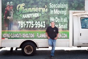 Todd leaning against the Flannery's Handymen moving truck