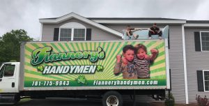 Flannery's Handymen moving truck with movers sitting on top of it