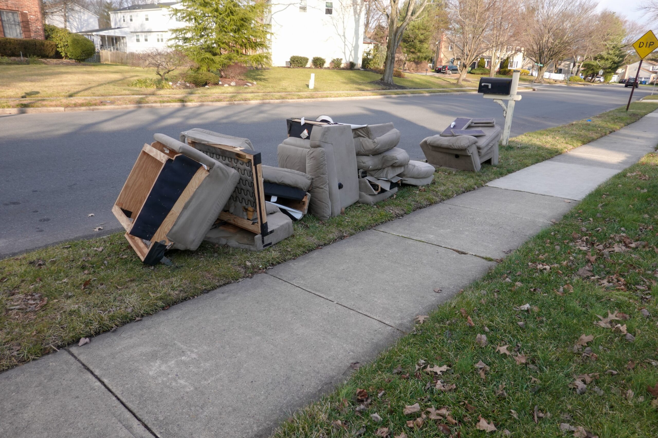 unwanted furniture items on curb of home waiting to be removed or picked up