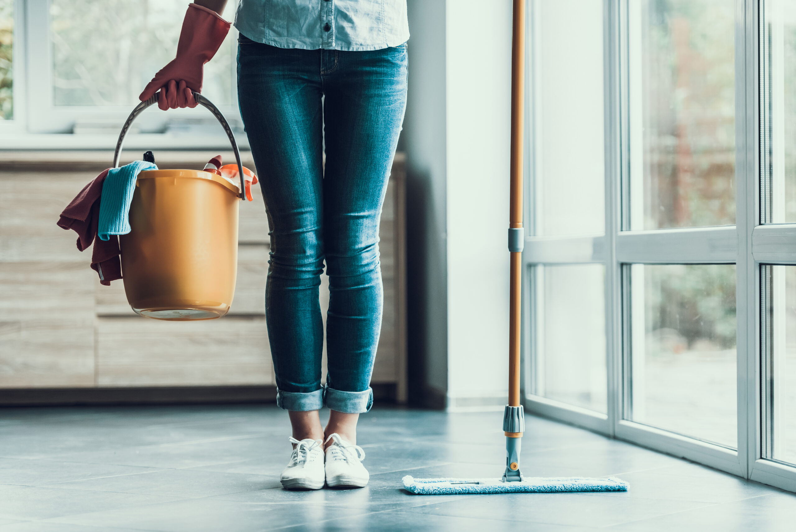 woman cleaning home with bucket and mop