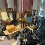 hoarder with old furniture, boxes, and bags in the way