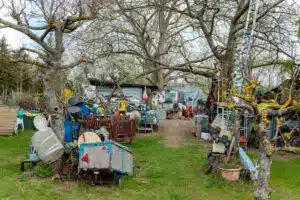 outside view of the front of a hoarder home with lots of junk items around